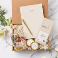 Load image into Gallery viewer, a box containing a note book, a cup of tea, a candle, and