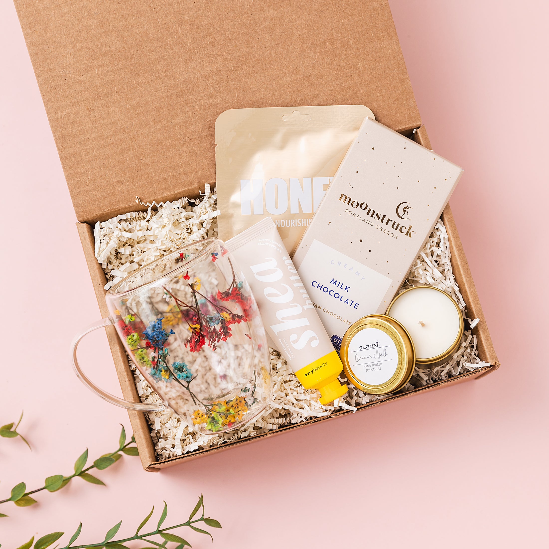 a box containing a candle, a candle holder, and some other items