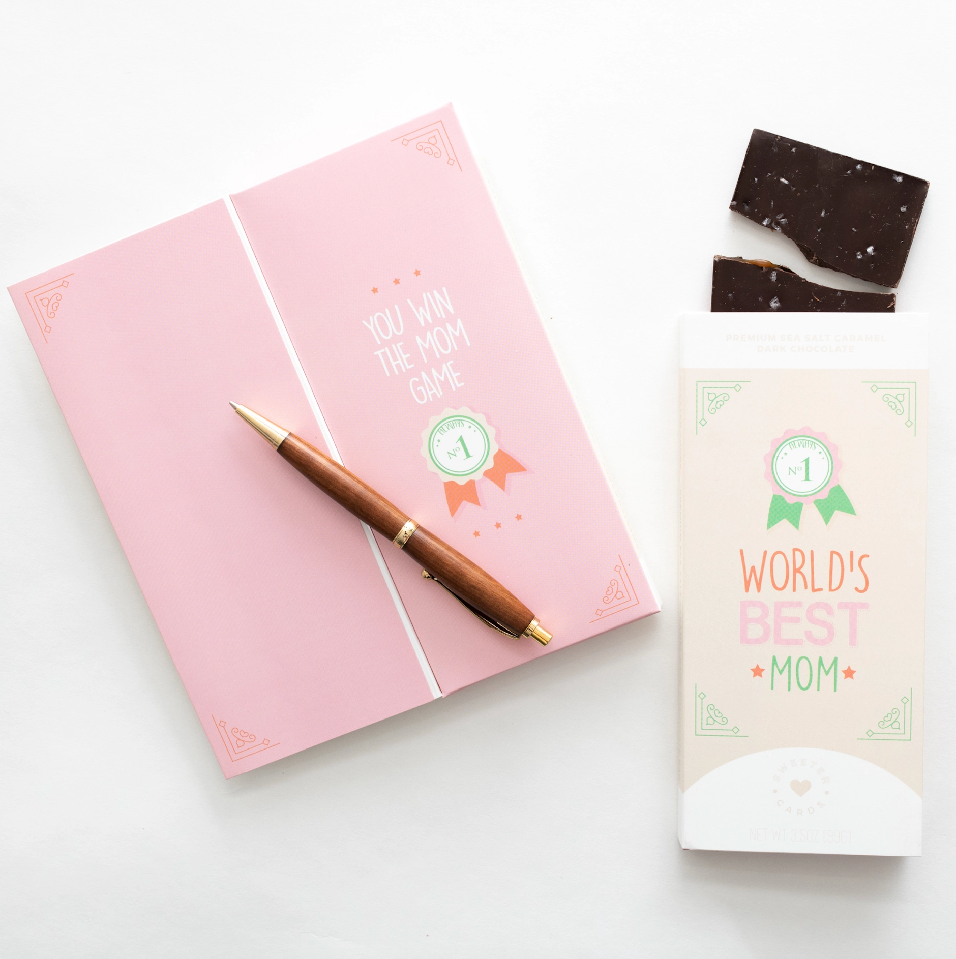 a notepad, pen, and chocolate bar on a table