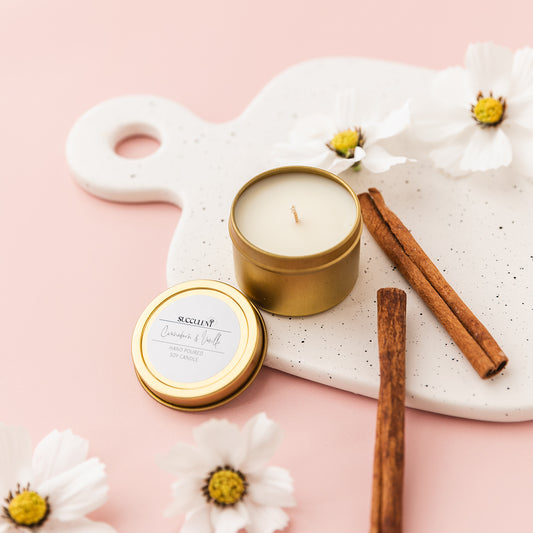 a candle and some cinnamon sticks on a tray