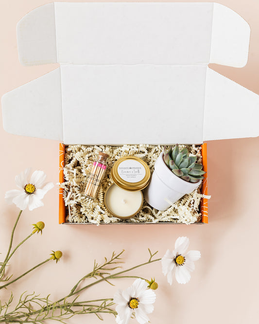 a box with some flowers and a candle in it