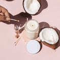 Load image into Gallery viewer, a person holding a spoon over a jar of coconut oil

