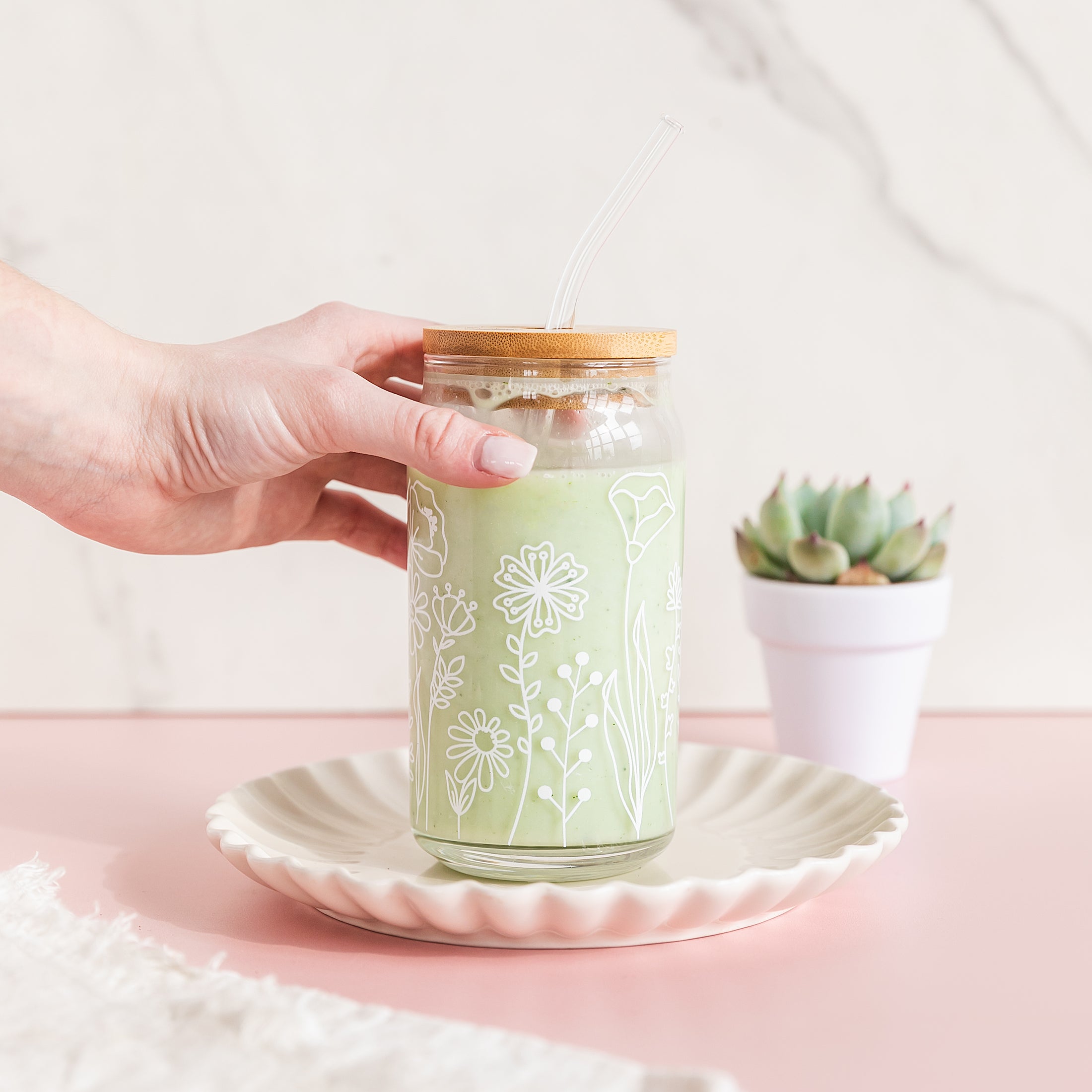 a person holding a jar with a straw in it