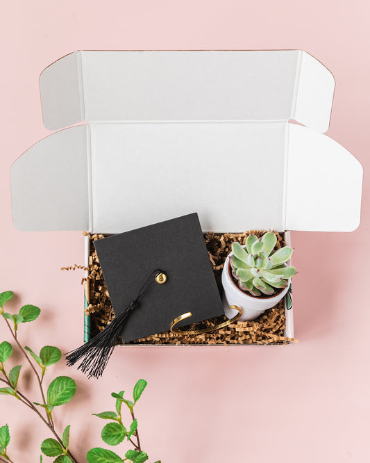 a graduation cap and a plant in a box