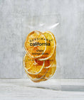 Load image into Gallery viewer, a bag of orange slices sitting on top of a table
