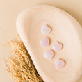 Load image into Gallery viewer, a wooden spoon with hearts on it next to a plant
