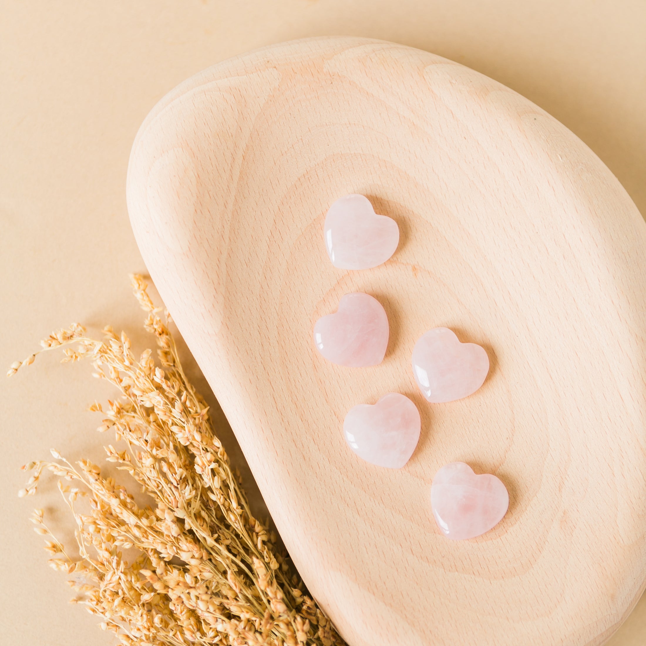a wooden spoon with hearts on it next to a plant
