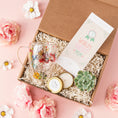 Load image into Gallery viewer, a box with a glass, a candle, and some flowers
