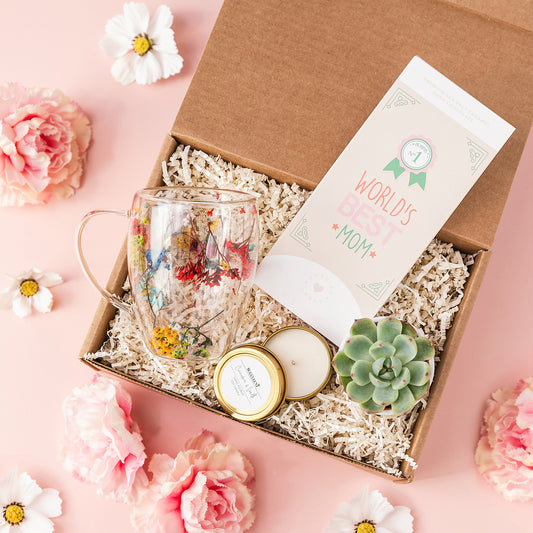 a box with a glass, a candle, and some flowers