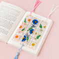 Load image into Gallery viewer, a book with a bookmark made out of flowers
