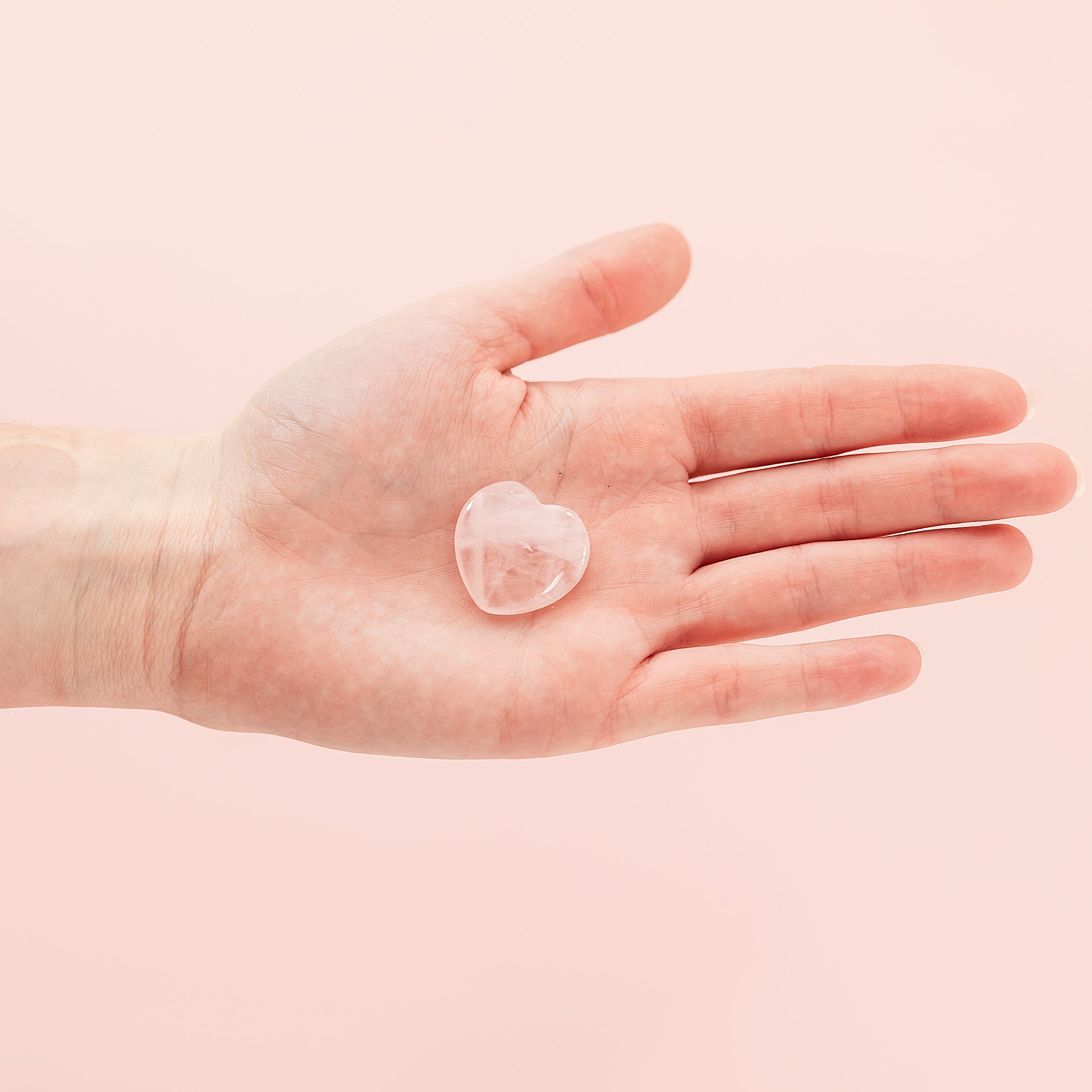 a person's hand holding a piece of clear glass