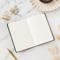Load image into Gallery viewer, an open notebook sitting on top of a table next to a pen
